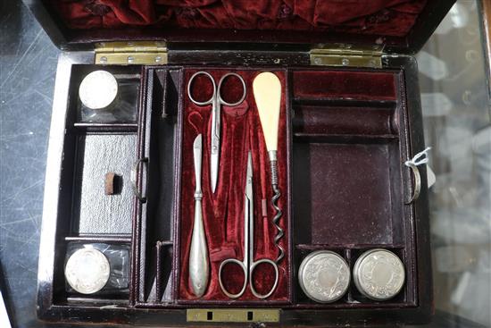 A Victorian brass mounted rosewood toilet box, containing four silver mounted bottles and four nail implements, box 28cm.